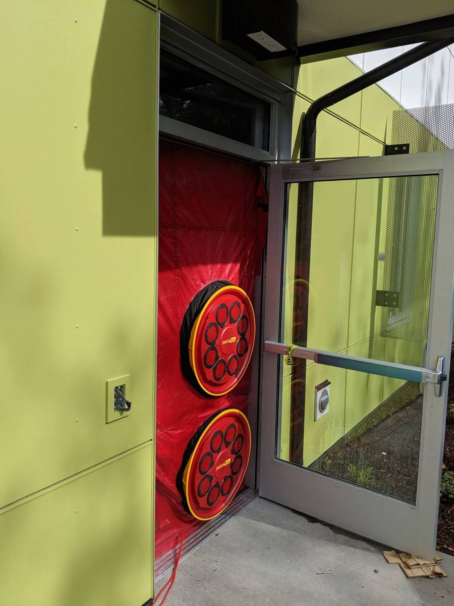 Blower door fans installed in a doorway for envelope testing